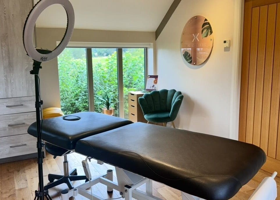Tranquil treatment room at KK Clinic, Ashby-de-la-Zouch, England, featuring a massage bed and modern decor.