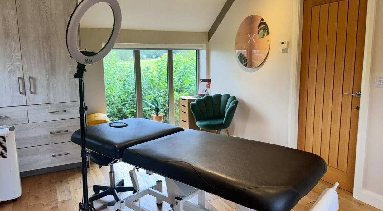 Tranquil treatment room at KK Clinic, Ashby-de-la-Zouch, England, featuring a massage bed and modern decor.