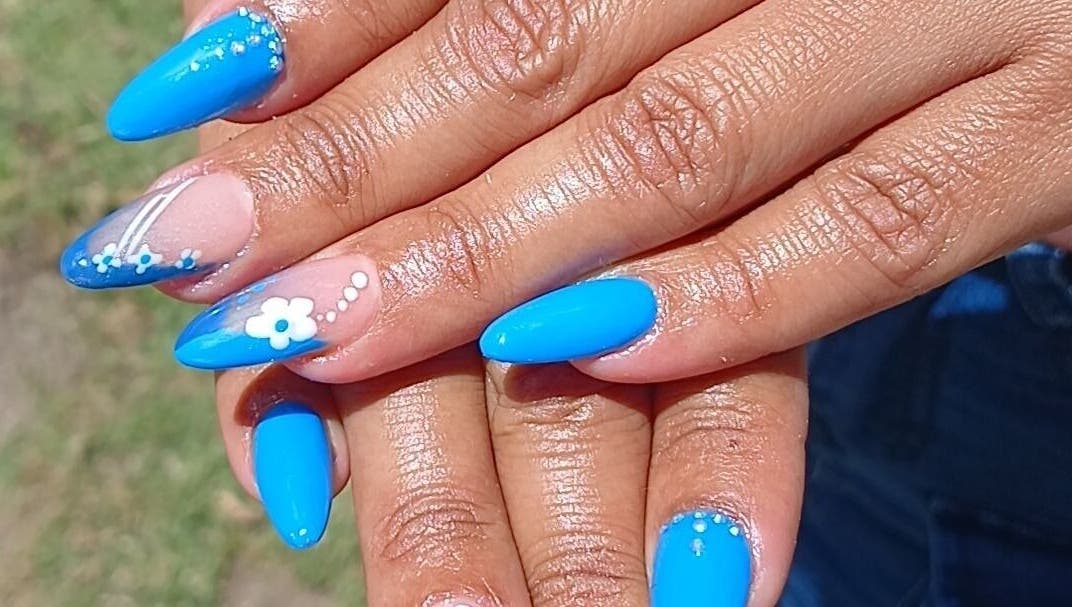 Bright blue manicured nails with floral designs at N&h nail bar, Humansdorp, Eastern Cape, ZA.