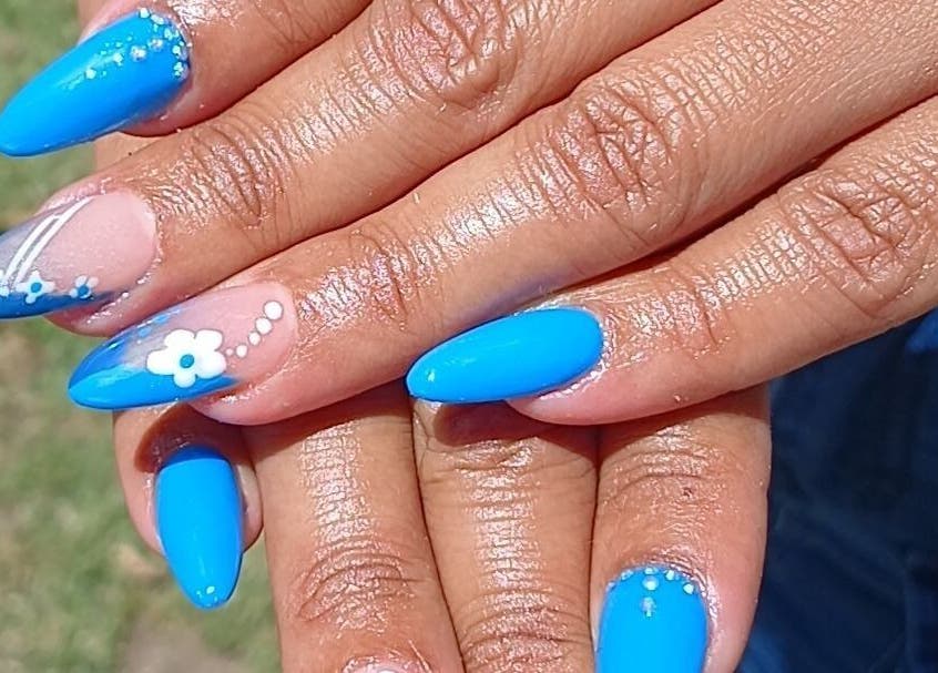 Bright blue manicured nails with floral designs at N&h nail bar, Humansdorp, Eastern Cape, ZA.