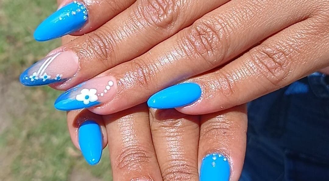 Bright blue manicured nails with floral designs at N&h nail bar, Humansdorp, Eastern Cape, ZA.