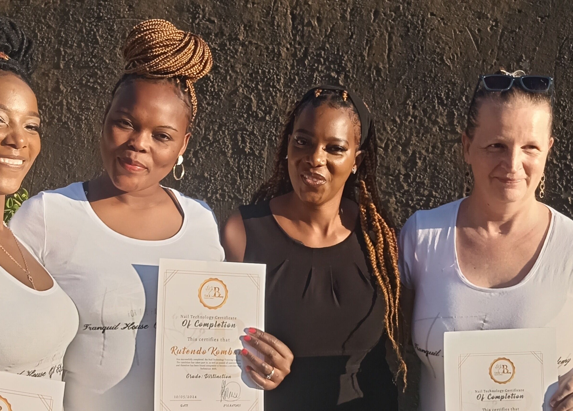Graduates celebrating at Tranquil House of Elegance Beauty/Academy, Roodepoort, Gauteng, ZA, holding certificates.