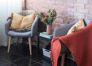 Inviting seating area at Tuca Salon, Melbourne, Victoria, AU, with comfy chairs and soft throws.
