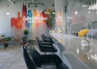 Interior of Color Me True Nail Bar in Nashville, Tennessee with vibrant mural and sleek seating.