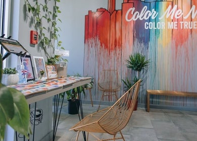 Colorful entrance at Color Me True Nail Bar in Nashville, Tennessee, US, with artistic wall decor and modern seating.