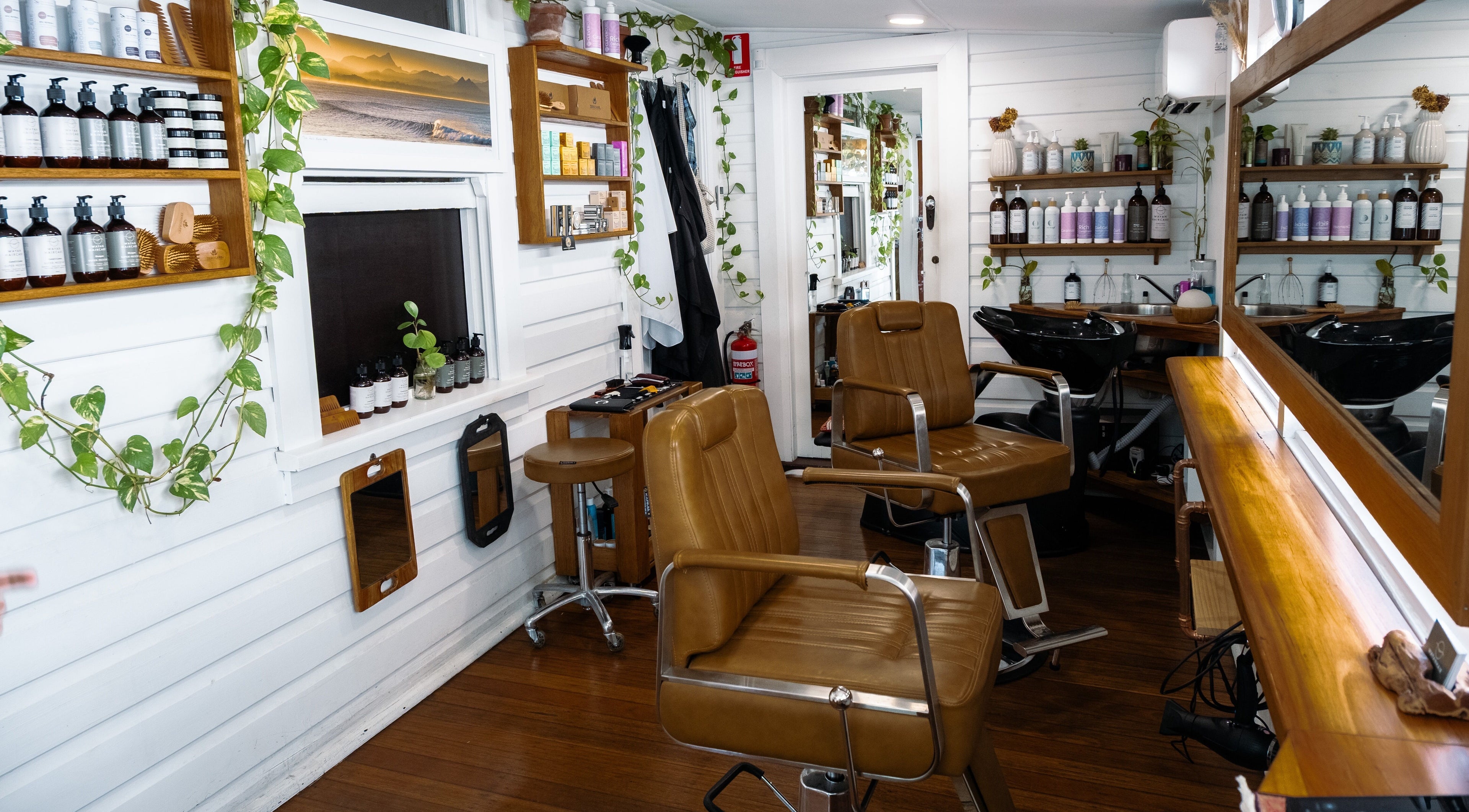 Chic interior of Wayan Hair salon in Mullumbimby, New South Wales, AU featuring stylish chairs and greenery.