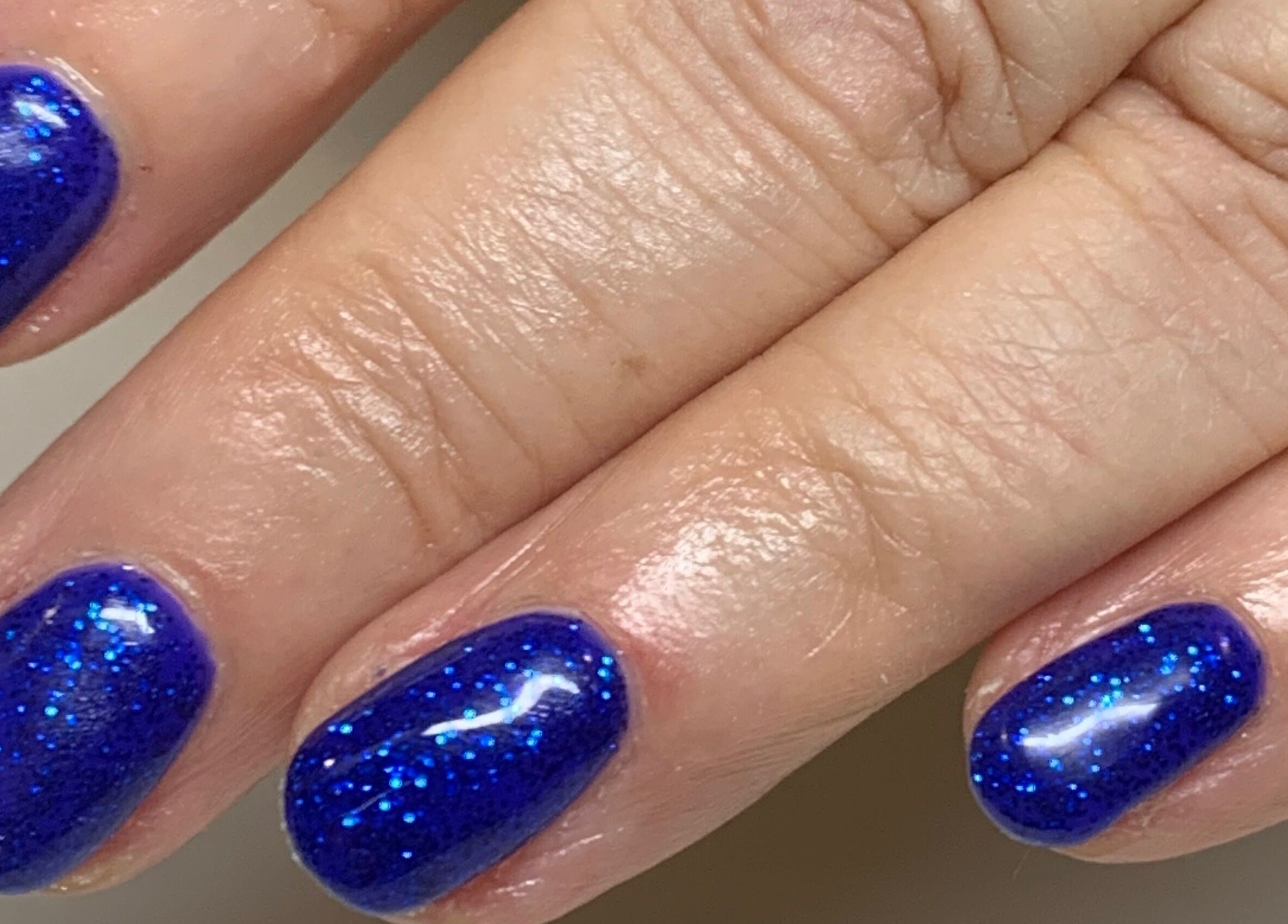 Vibrant blue glitter manicure at Bridie’s Beauty at Flutterbye Lashes, Lowestoft, England, GB.