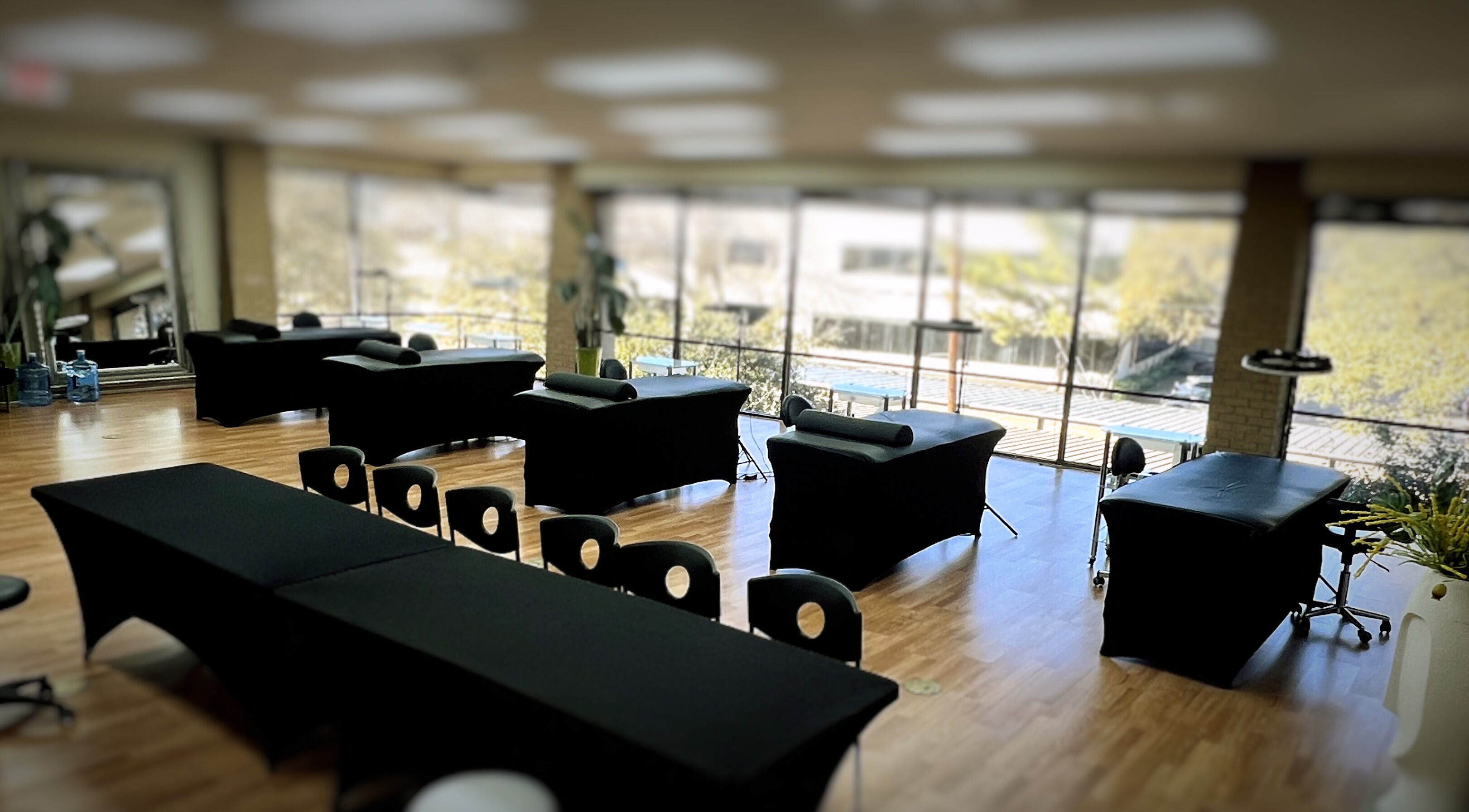 Spacious, sunlit interior of 5 Star Academy, Dallas, Texas, US with massage tables and large windows.