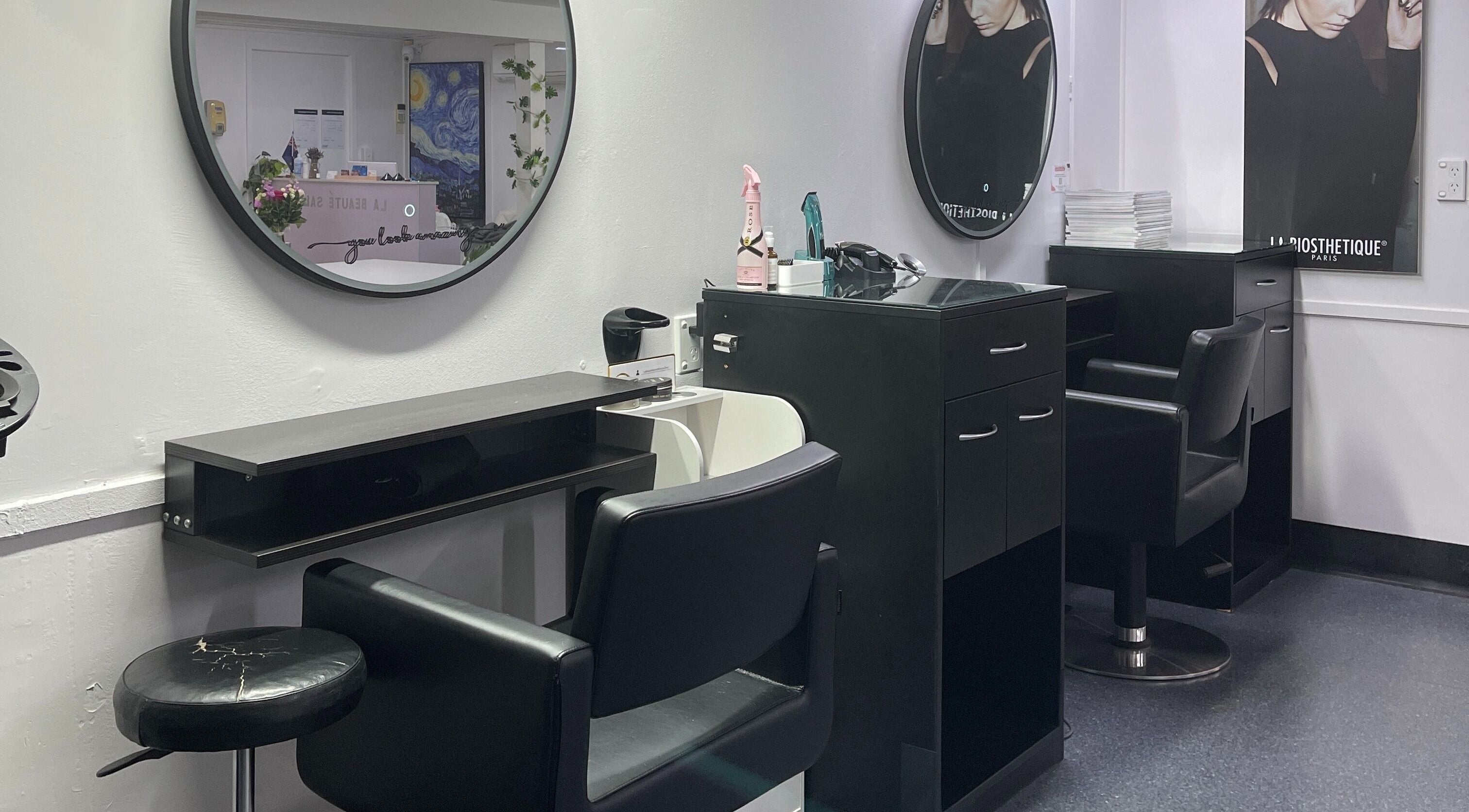 Modern styling stations at La Beauté Hair and Beauty Clinic, Auckland, NZ with elegant mirrors and chairs.