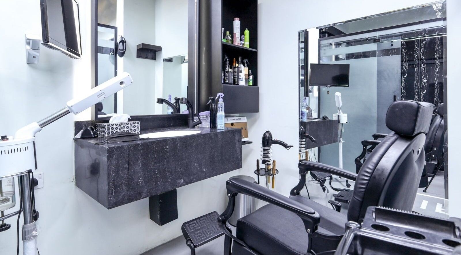 Modern salon interior at The Diamond Wolf in Riyadh, Riyadh Province, SA featuring black styling chairs.