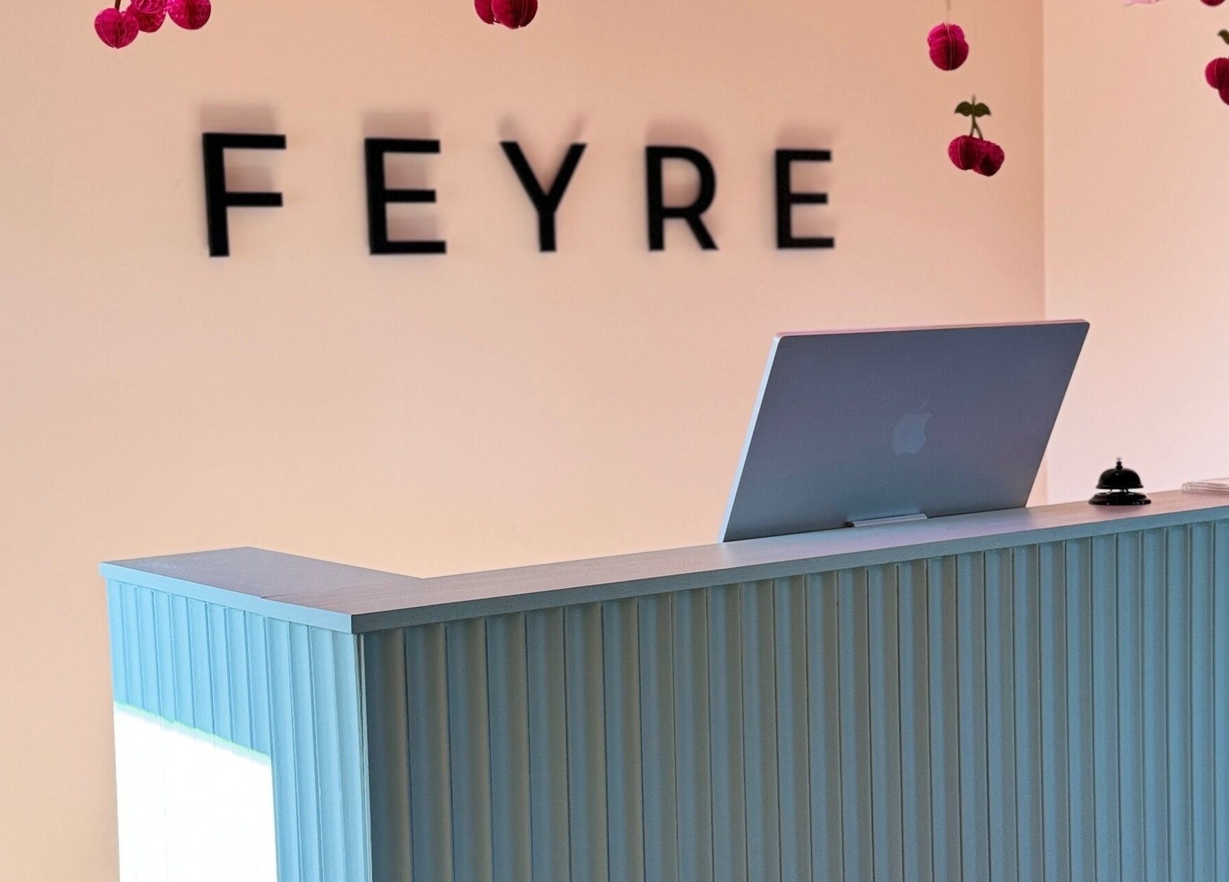 Reception desk at Feyre Ilusalong, Pärnu, Pärnu Maakond, EE, with modern decor and hanging flowers.