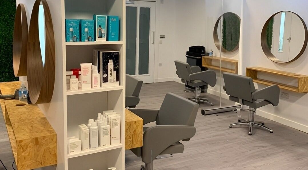 Stylish interior of Hope James Hair in Haddington, Scotland, GB, featuring modern chairs and hair products.