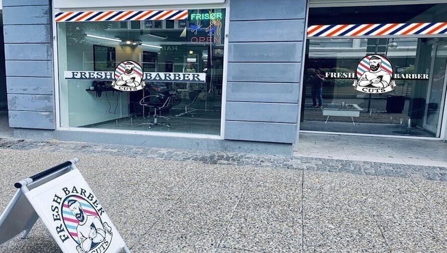 Friskt Barber Cuts' moderne facade i Herning, DK med stilfuldt interiør og tydelig skiltning.