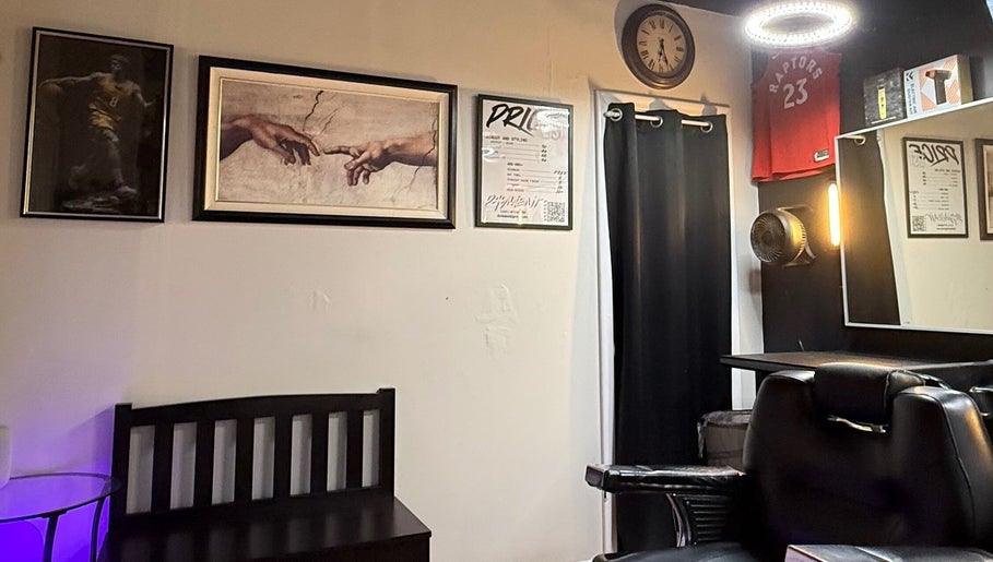 Interior of Daniel Coto Barber Studio, featuring art and clock on wall in Hamilton, Ontario, CA.