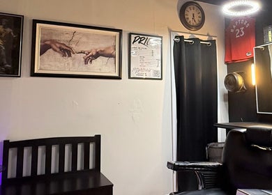 Interior of Daniel Coto Barber Studio, featuring art and clock on wall in Hamilton, Ontario, CA.