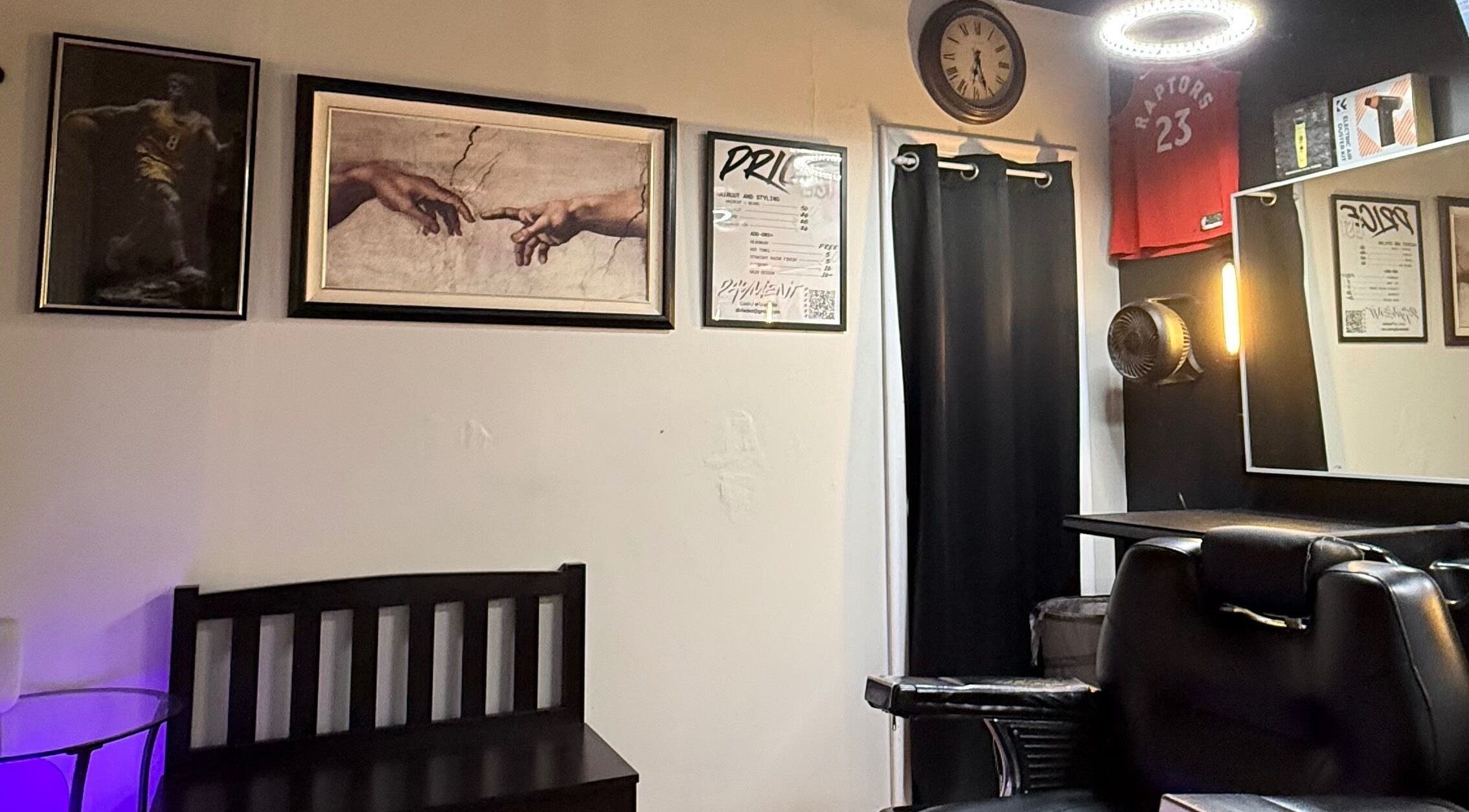 Interior of Daniel Coto Barber Studio, featuring art and clock on wall in Hamilton, Ontario, CA.