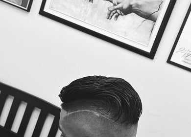 Sleek haircut at Daniel Coto Barber Studio in Hamilton, Ontario, CA, featuring artistic wall art.