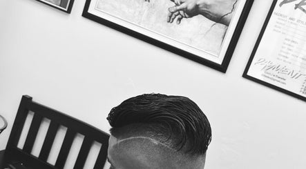 Sleek haircut at Daniel Coto Barber Studio in Hamilton, Ontario, CA, featuring artistic wall art.