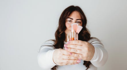 Woman holding beauty tools at Sunshine Aesthetics in Roseville, Minnesota, US, showcasing salon services.