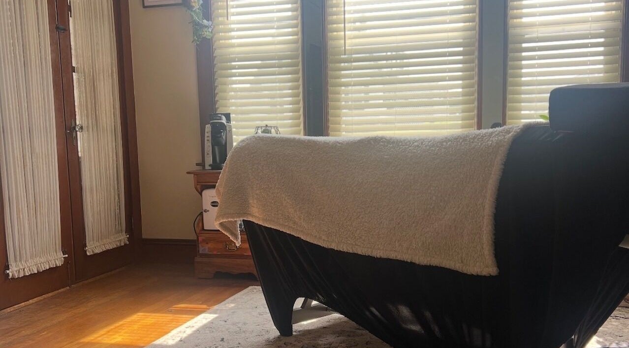 Cozy massage room at Artistry By Alex, Westerly, Rhode Island, US with soft lighting and comfortable bed.