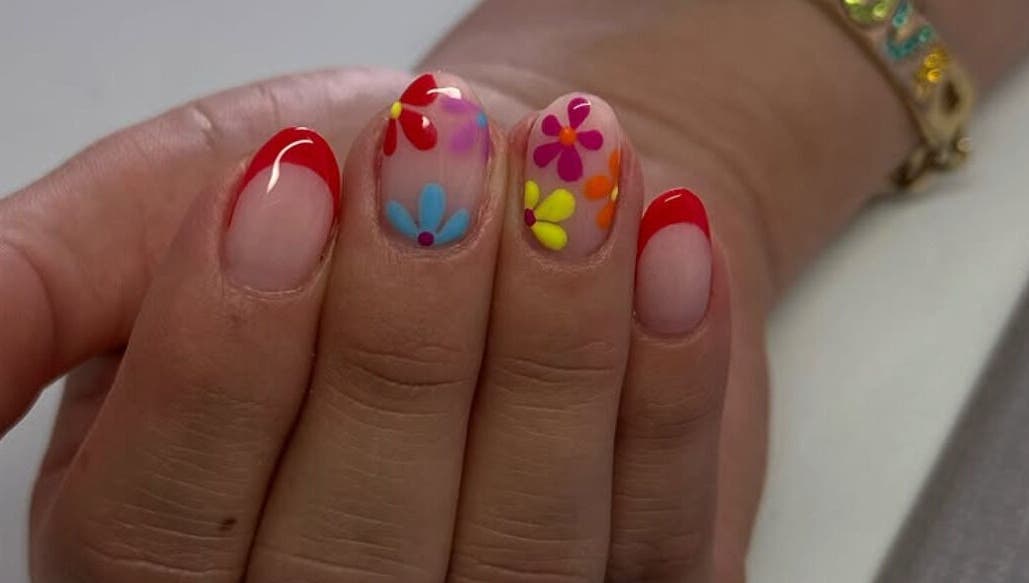 Uñas decoradas con flores y punta roja en Douxemxestadio, Morelia, Michoacán, MX.