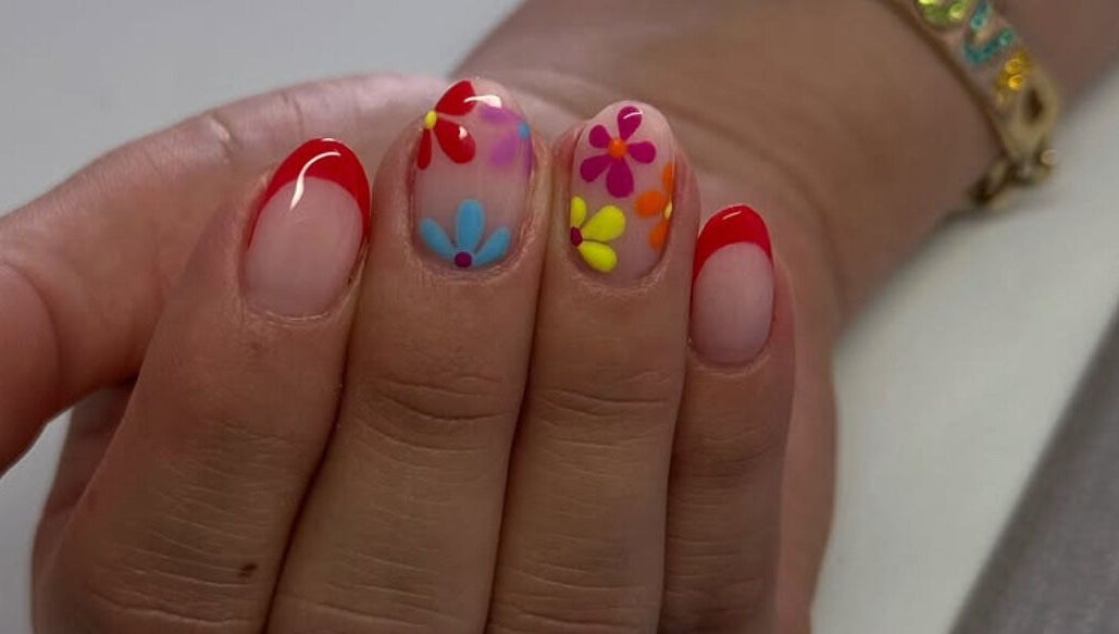 Uñas decoradas con flores y punta roja en Douxemxestadio, Morelia, Michoacán, MX.