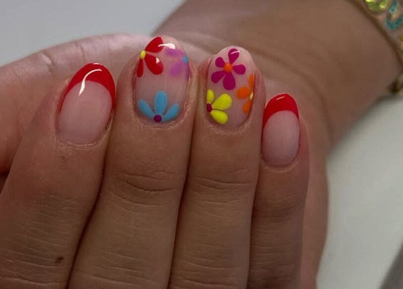Uñas decoradas con flores y punta roja en Douxemxestadio, Morelia, Michoacán, MX.