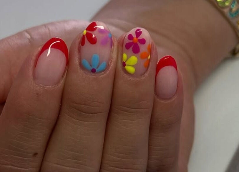 Uñas decoradas con flores y punta roja en Douxemxestadio, Morelia, Michoacán, MX.