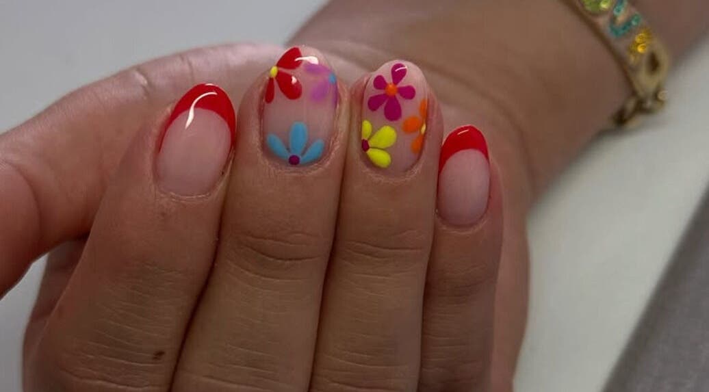 Uñas decoradas con flores y punta roja en Douxemxestadio, Morelia, Michoacán, MX.