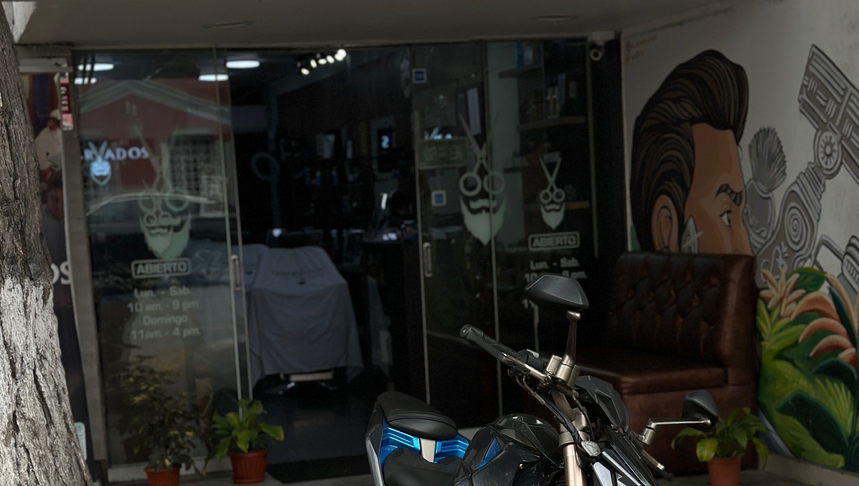 Vista de Enbarvados Barbería en Miraflores, Provincia De Lima, PE con decoración moderna y motocicleta afuera.