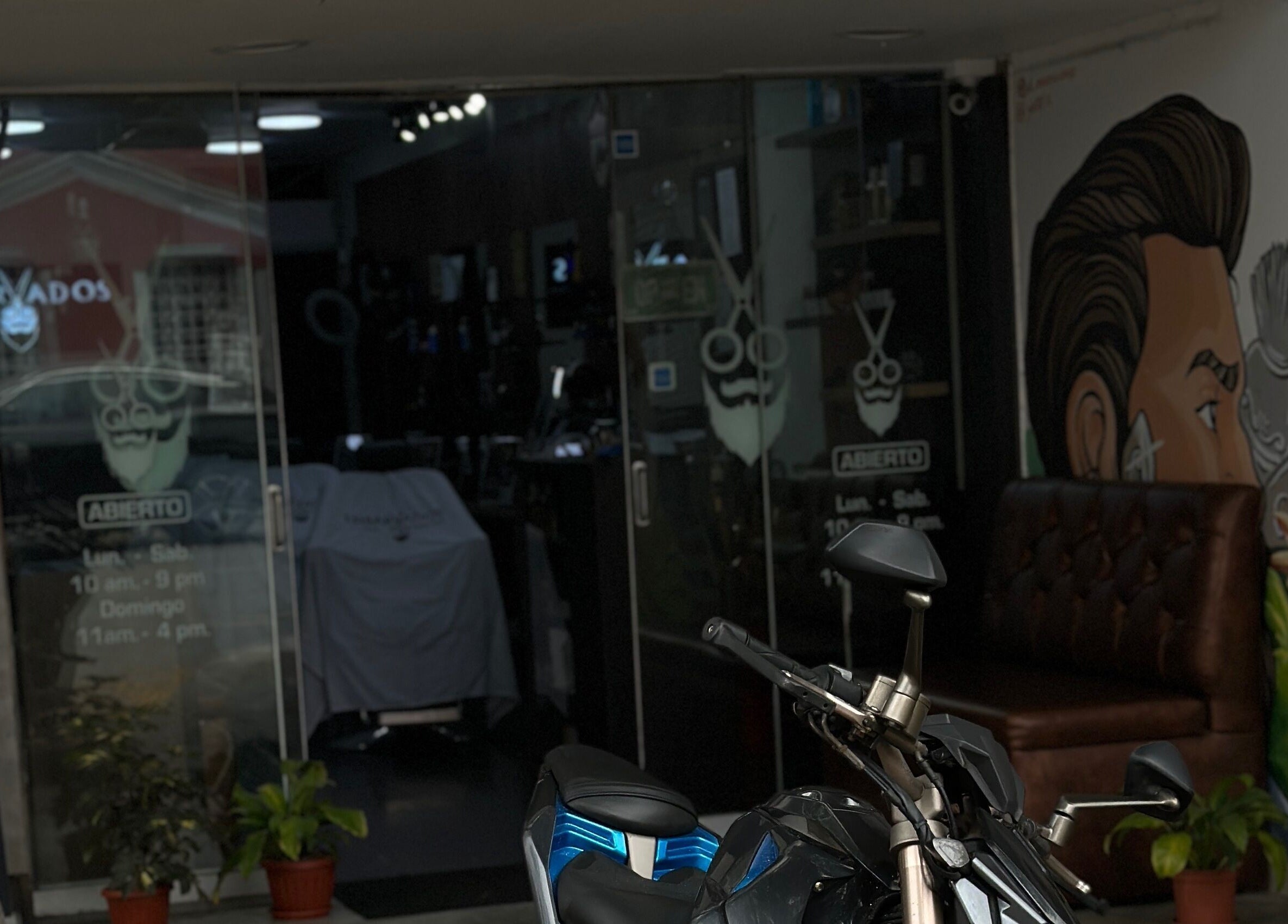 Vista de Enbarvados Barbería en Miraflores, Provincia De Lima, PE con decoración moderna y motocicleta afuera.