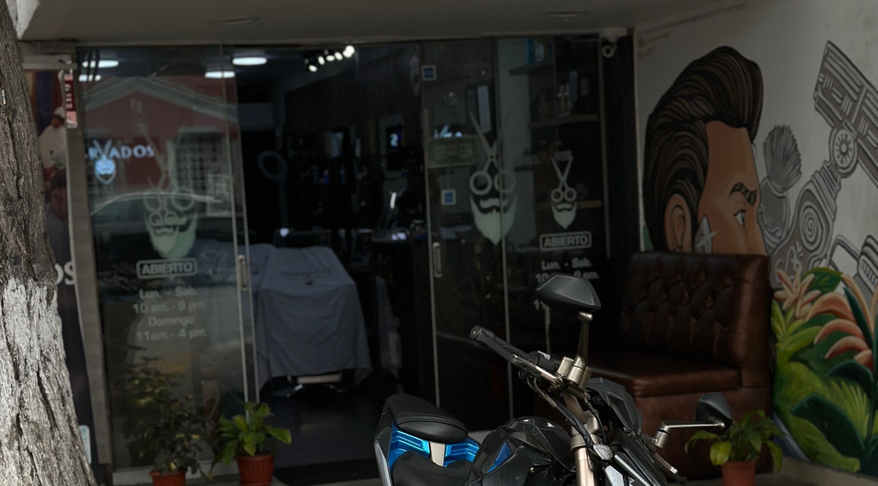 Vista de Enbarvados Barbería en Miraflores, Provincia De Lima, PE con decoración moderna y motocicleta afuera.
