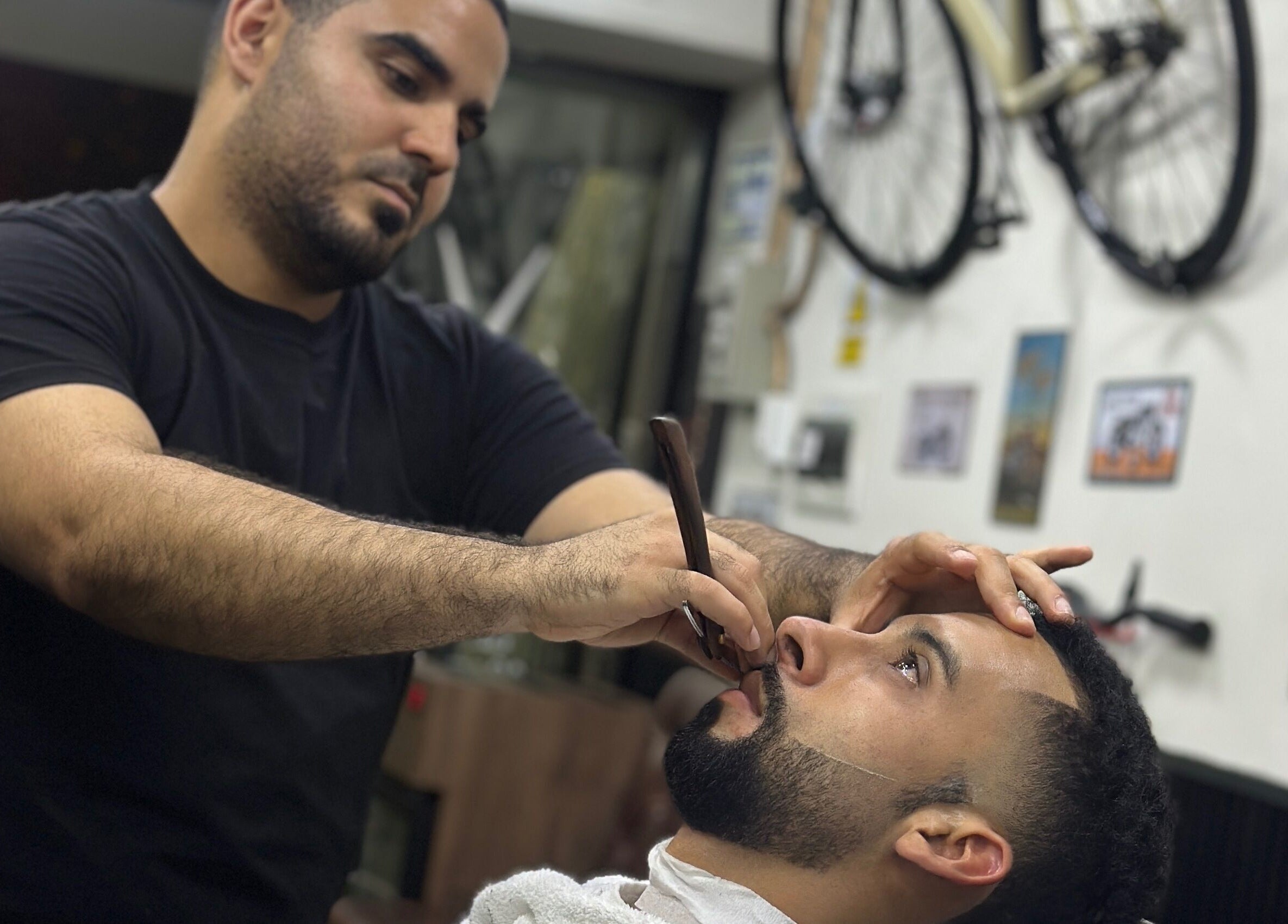 Barbero realizando afeitado preciso en Enbarvados Barbería, Miraflores, Provincia De Lima, PE.