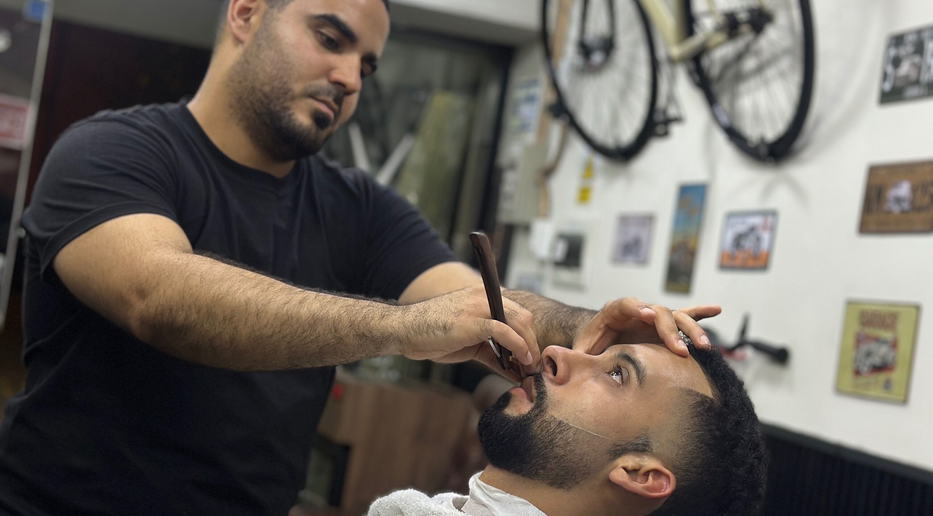 Barbero realizando afeitado preciso en Enbarvados Barbería, Miraflores, Provincia De Lima, PE.