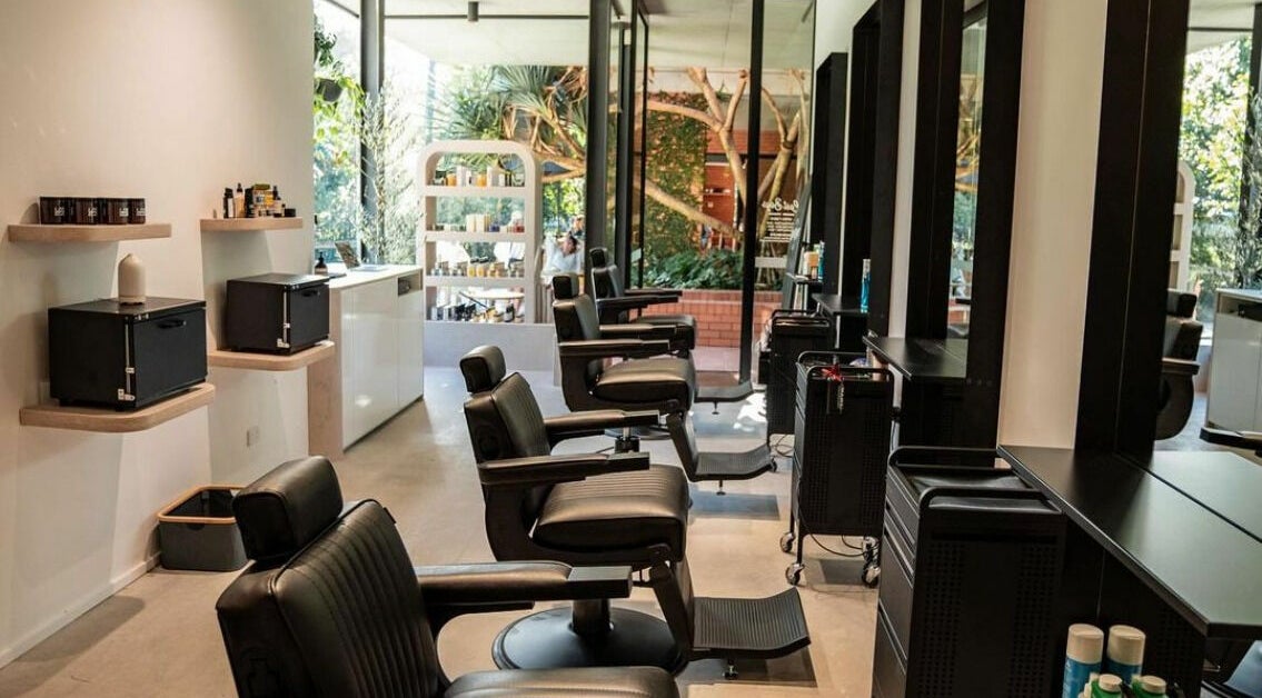 Modern salon interior at Lost Boys Burleigh, Burleigh Heads, Queensland, AU with sleek black chairs.