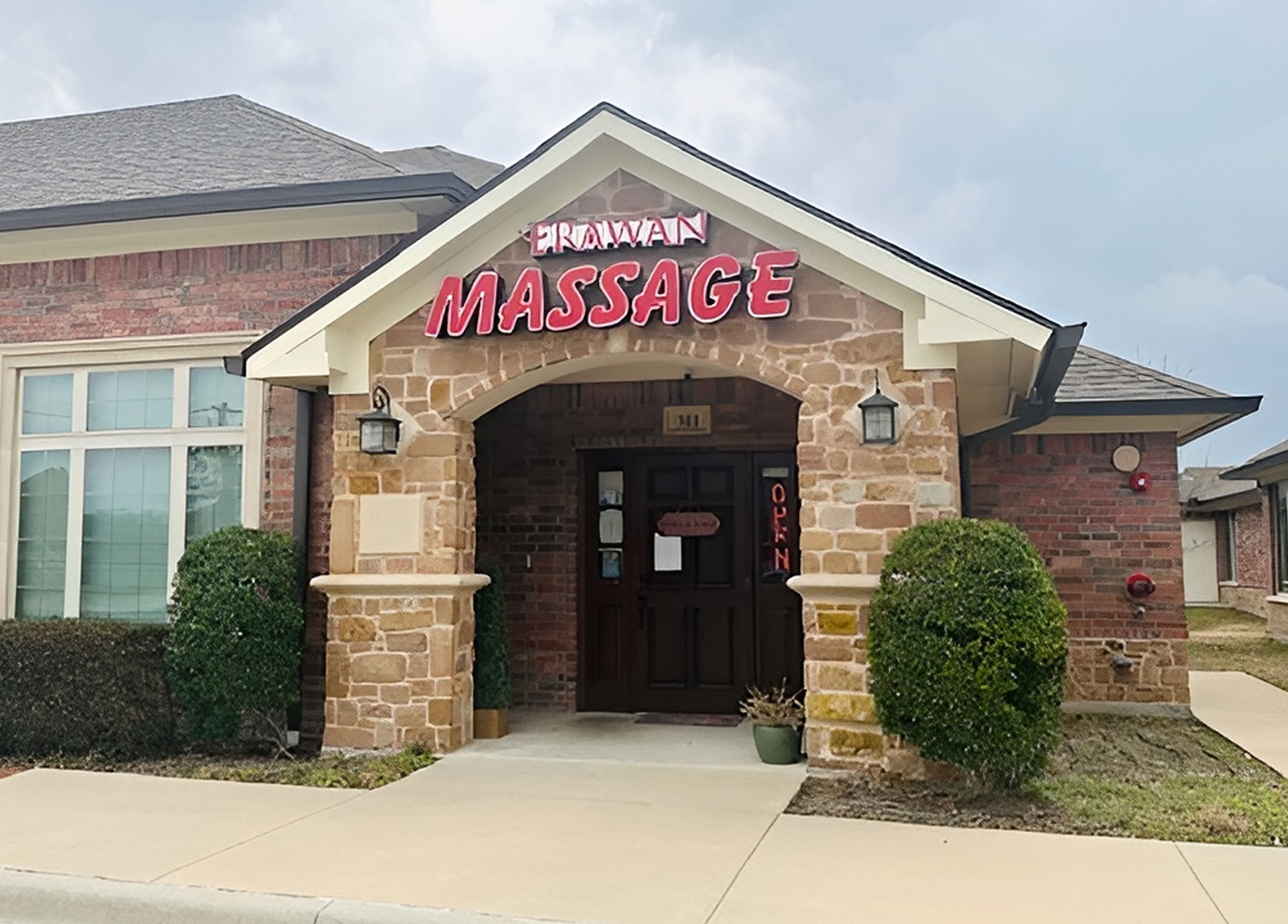 Entrance of Erawan Thai Massage at Frisco, showcasing inviting stone and brick facade, Frisco, Texas, US.