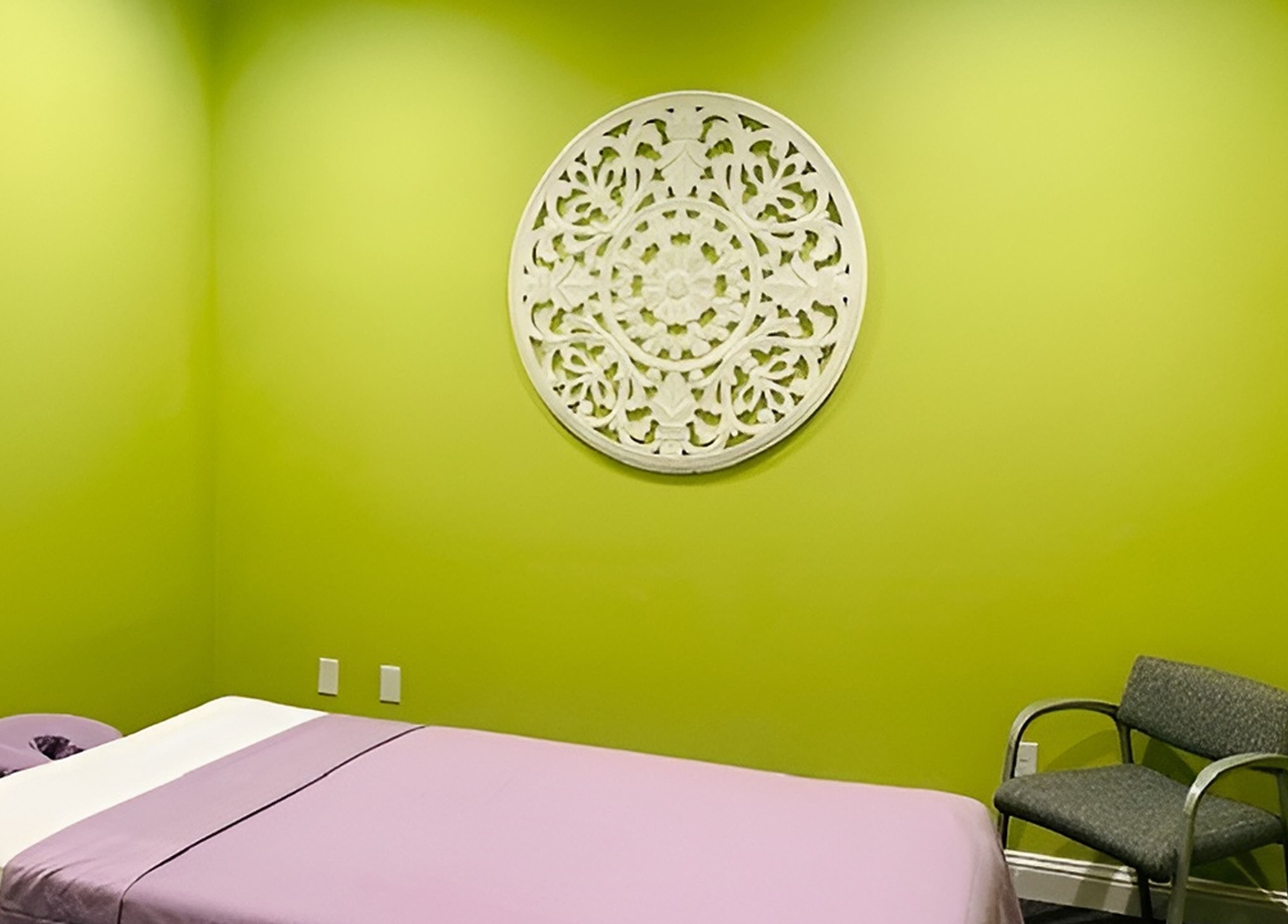 Tranquil massage room at Erawan@Prosper with lime green walls, located in Prosper, Texas, US.