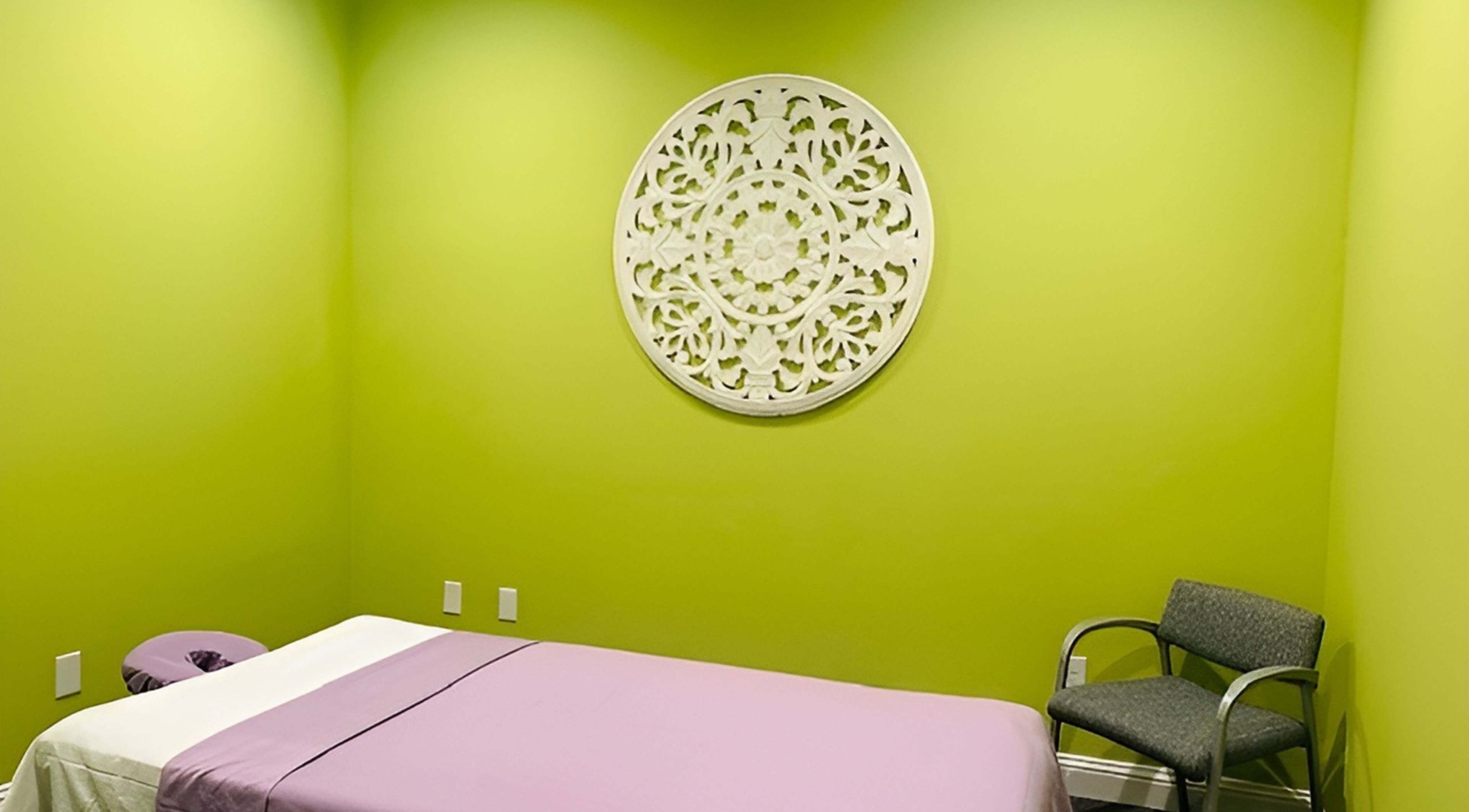 Tranquil massage room at Erawan@Prosper with lime green walls, located in Prosper, Texas, US.