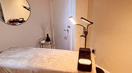 Calm therapy room at Aphrodite Lash, Worsbrough, England, GB, featuring cozy lighting and a treatment bed.