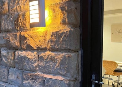 Inviting stone entrance lit at Aphrodite Lash, Worsbrough, England. A cozy ambiance welcomes visitors.
