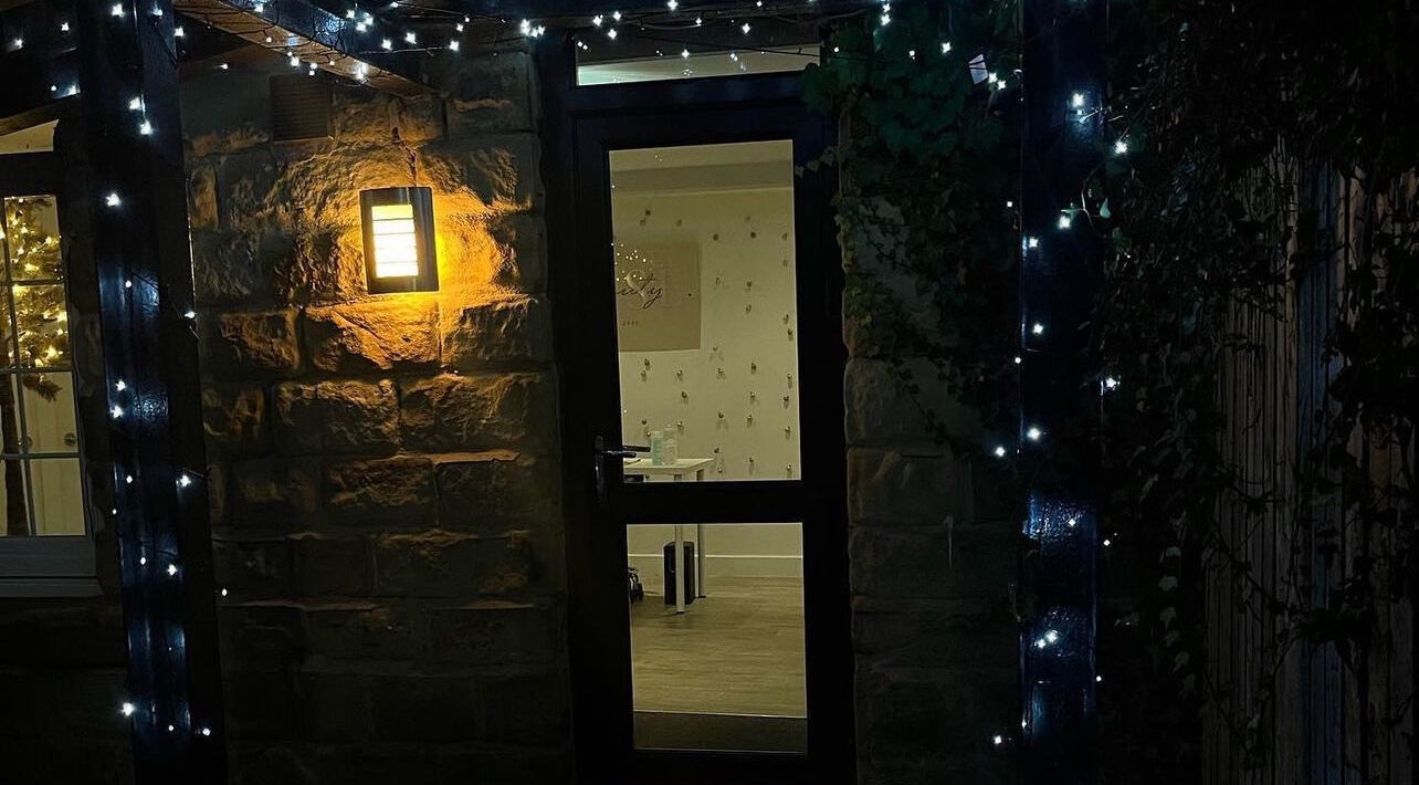 Entrance of Aphrodite Lash in Worsbrough, England, GB, lit by warm lights and fairy string lights.