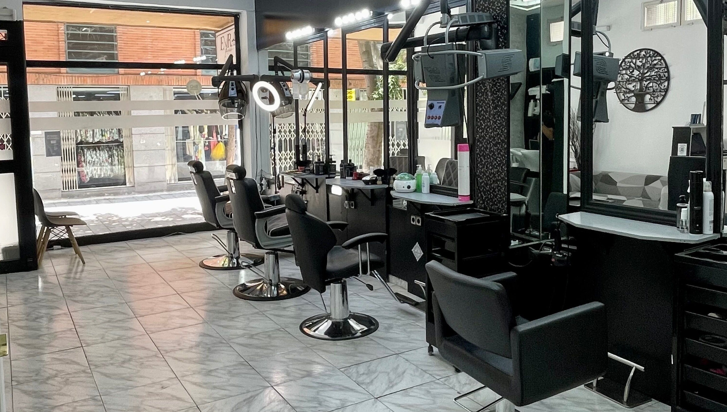 Interior moderno de Eyra Artisti en Madrid, Comunidad De Madrid, ES, mostrando sillas de estilista y espejos.