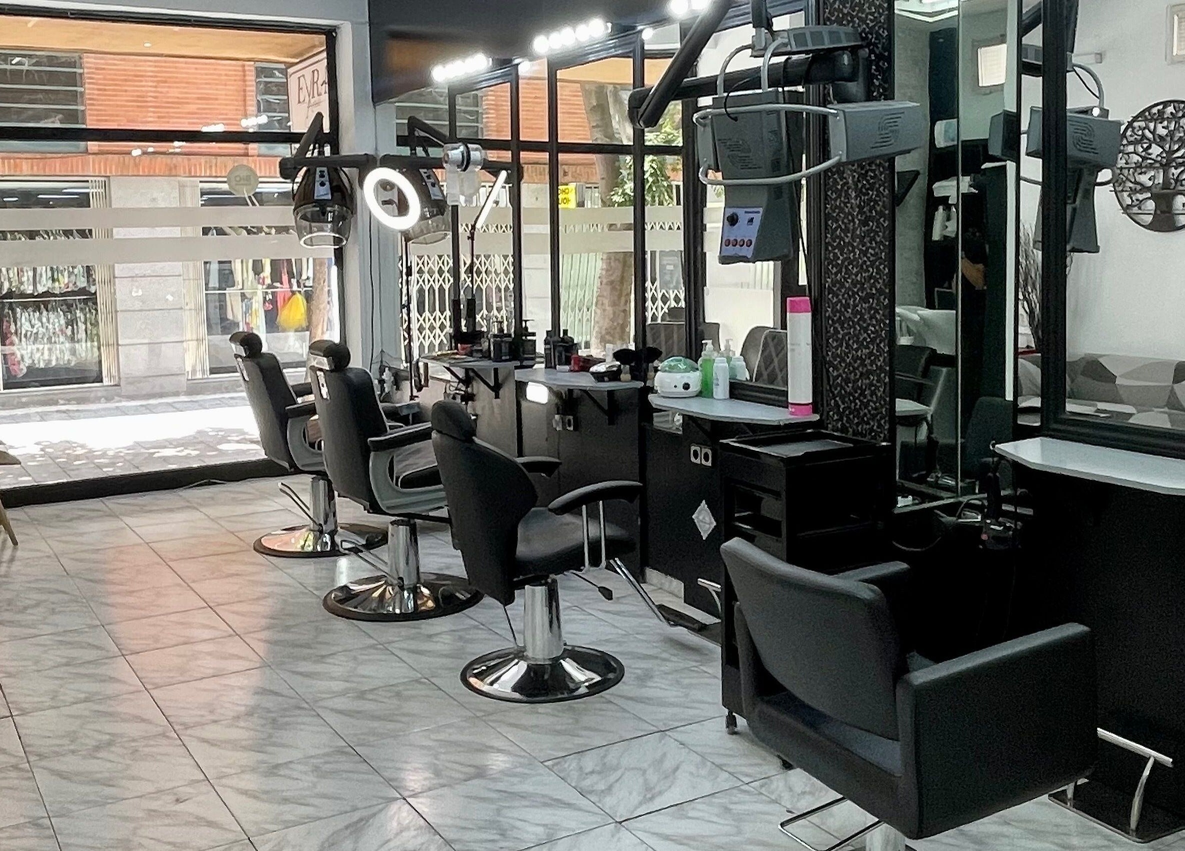 Interior moderno de Eyra Artisti en Madrid, Comunidad De Madrid, ES, mostrando sillas de estilista y espejos.