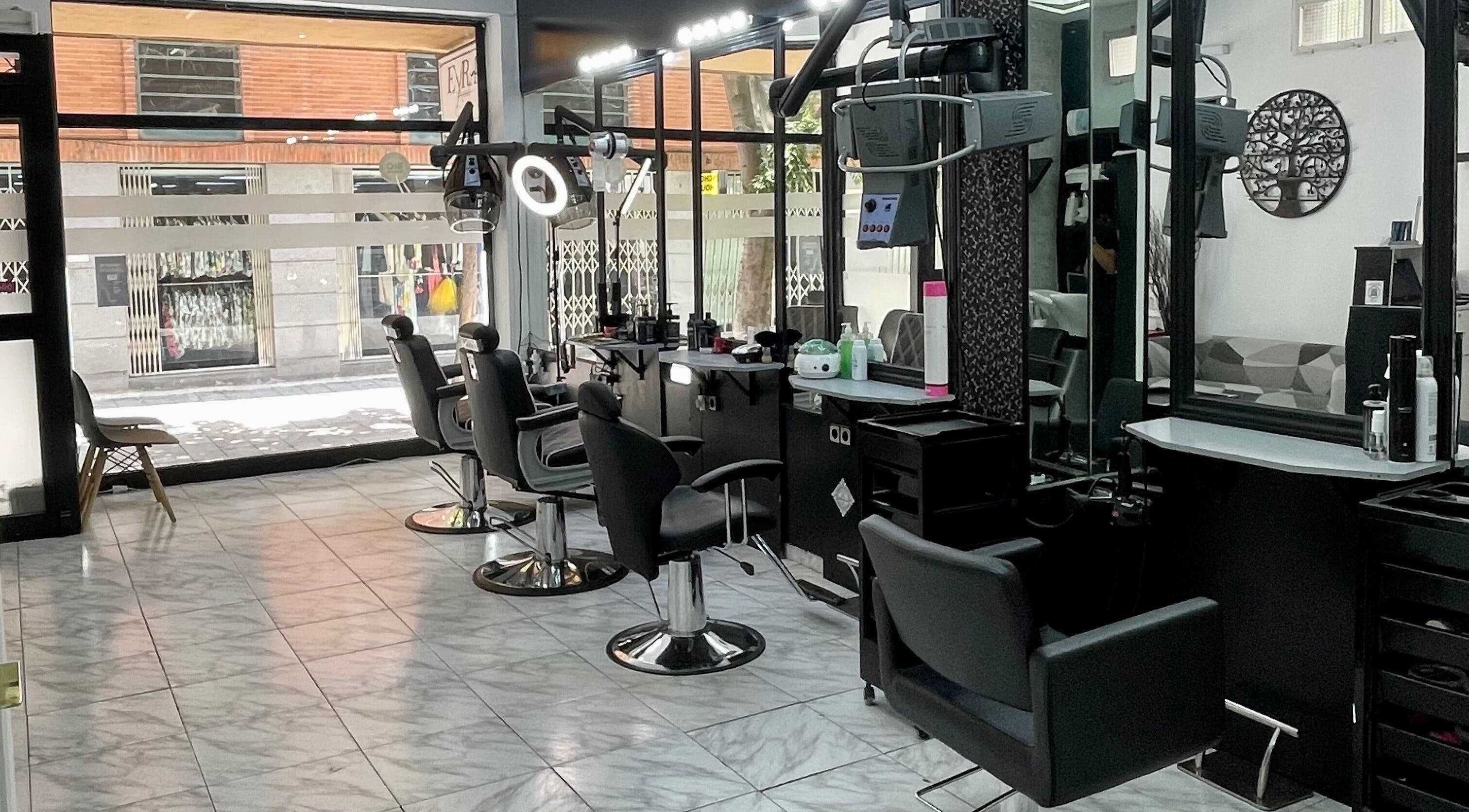 Interior moderno de Eyra Artisti en Madrid, Comunidad De Madrid, ES, mostrando sillas de estilista y espejos.