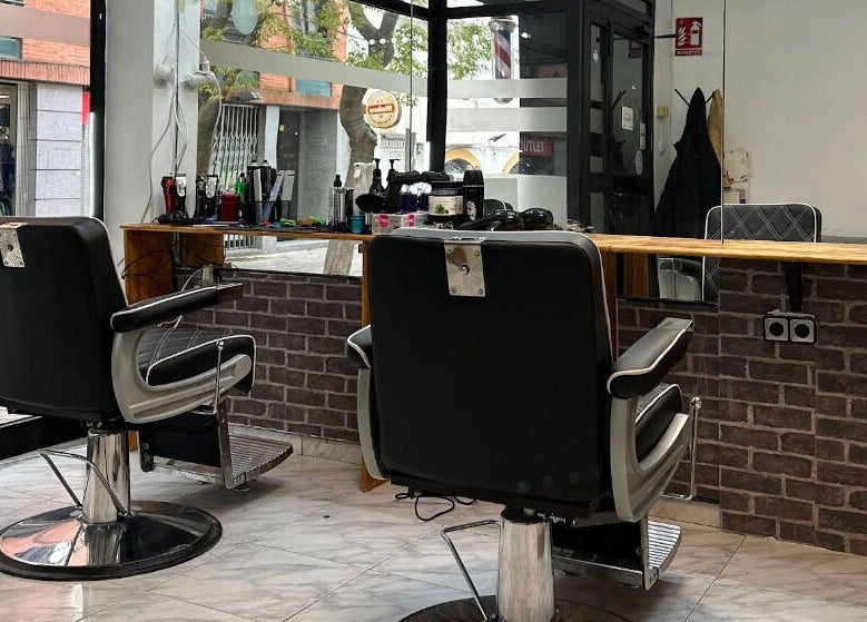 Interior moderno de Eyra Artisti en Madrid, Comunidad De Madrid, ES. Sillas de peluquería frente a un espejo amplio.