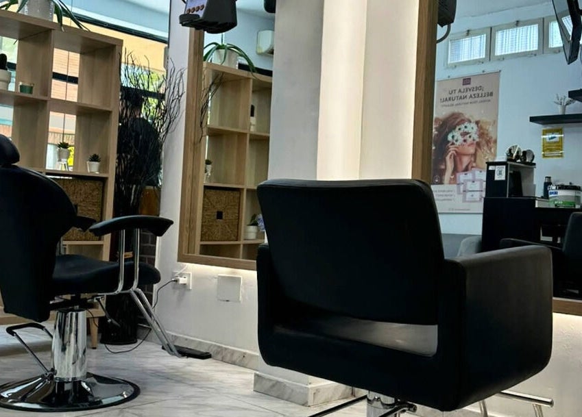 Interior moderno de salón en Eyra Artisti, Madrid, Comunidad De Madrid, ES, con sillas elegantes y espejos iluminados.