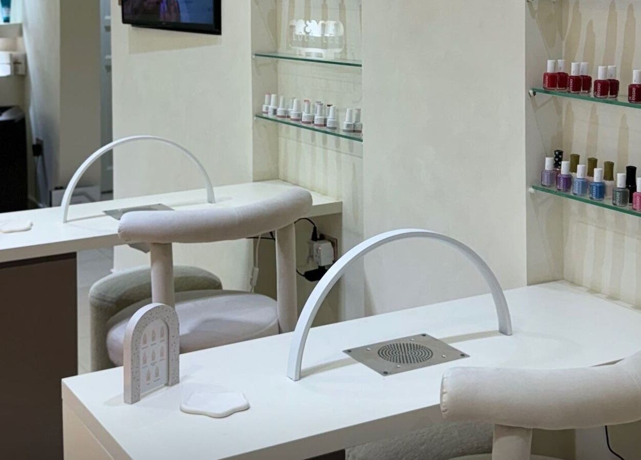 Nail treatment area at Ray Spa Beauty Center, Al Ain, Abu Dhabi, AE, featuring manicure stations and polish display.