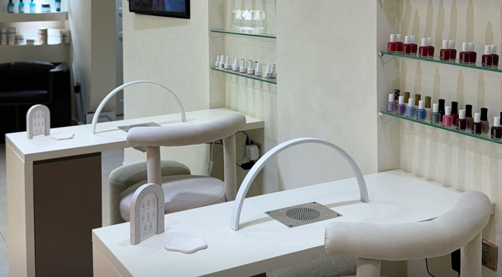 Nail treatment area at Ray Spa Beauty Center, Al Ain, Abu Dhabi, AE, featuring manicure stations and polish display.