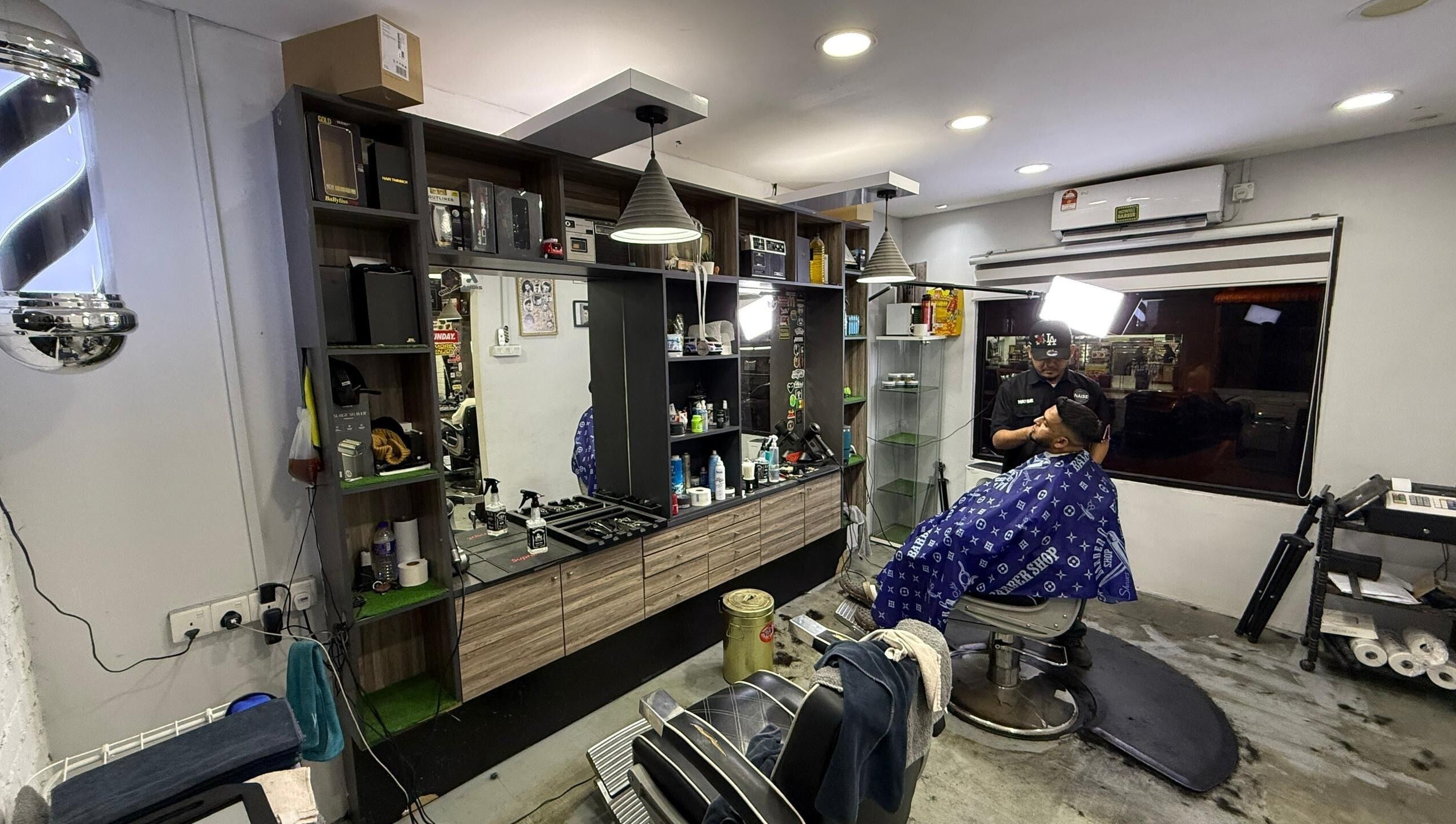 Interior of Brothers Barbershop Tiram showing barber and client in Ulu Tiram, Johor, MY.