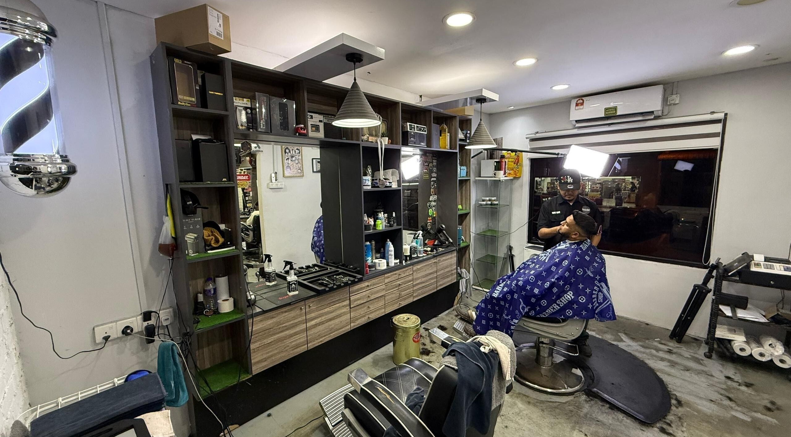 Interior of Brothers Barbershop Tiram showing barber and client in Ulu Tiram, Johor, MY.
